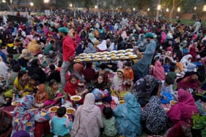 Volunteers serve meals to families during the holy fasting month of Ramadan at a free meal distribution point run by a charity group in Lahore, Pakistan