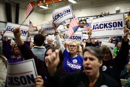 Supporters wave Troy Jackson campaign signs and flags, cheering at a rally