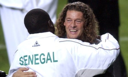 Senegal's French coach Bruno Metsu embraces a member of his team after the final whistle.