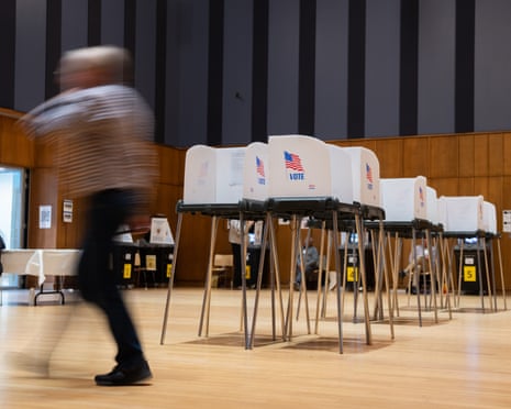A voter walks past a row of voting booths during early voting