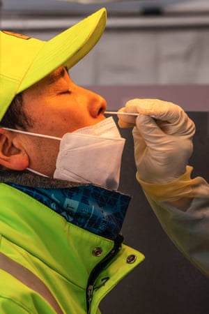 A man with a protective mask is performing a nasal swab test at the Covid-19 temporary test site in Seoul Square.