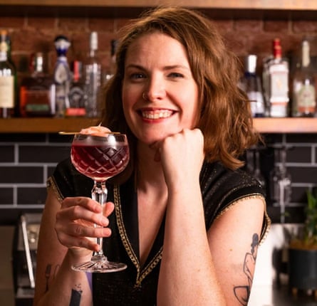 Cara Devine holds up a cocktail