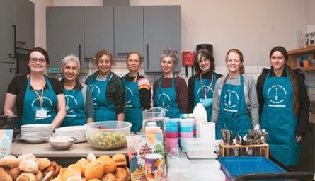 ETNA workers with food, drink, plates and cutlery at the community centre