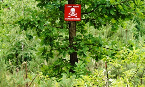 A sign warns of mines near the Irpin River, which was reflooded by the Ukrainian army to block Russian forces in the early days of the war.