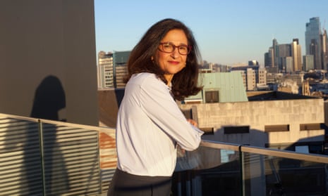 Minouche Shafik on the roof of the London School of Economics on a sunny day, lea ing against a balcony rail and smiling over her shoulder