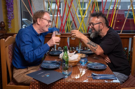 Two men sitting facing each other across a restaurant table