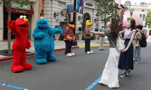 Sesame Street characters demonstrate how to greet visitors while keeping social distancing guidelines at Universal Studios Japan.