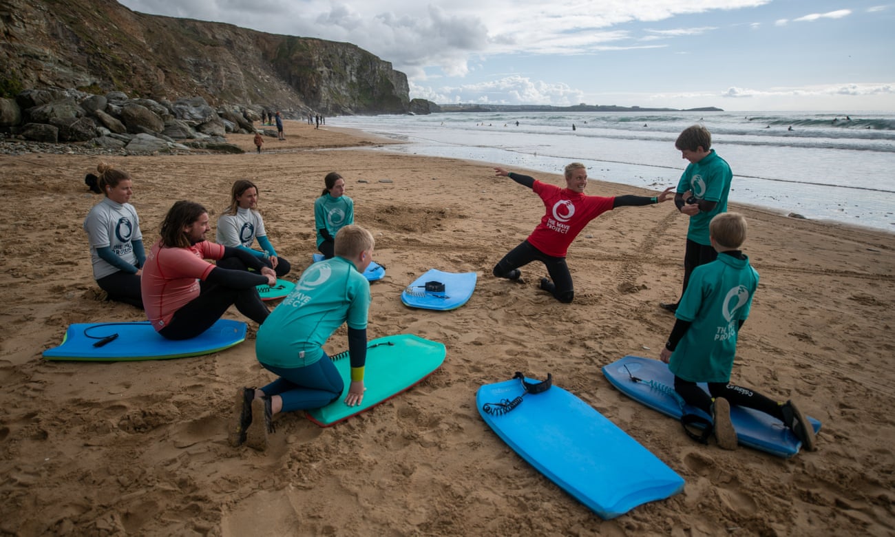 A Wave Project instructor giving a surfing lesson at Watergate Bay in Cornwall