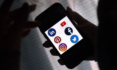 This file photo illustration picture shows social media applications logos from Linkedin, YouTube, Pinterest, Facebook, Instagram and Twitter displayed on a smartphone