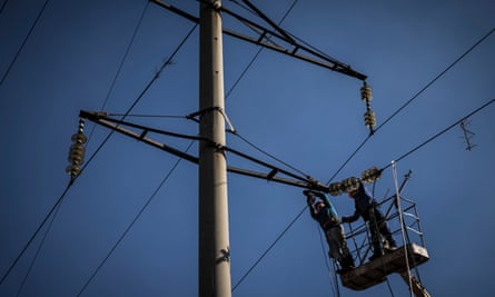 Workers in the suburbs of Bombay repair power lines damaged by the attack