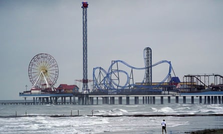 A man walks along the beach Wednesday in Galveston, Texas, as Hurricane Laura moves toward the Gulf Coast.