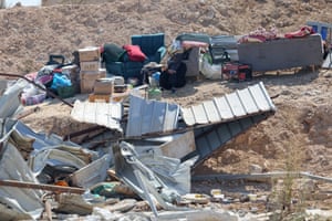 A Bedouin woman sits next to her belongings
