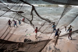 Children play along the eroded coastline after the tide receded in Bargny, Senegal
