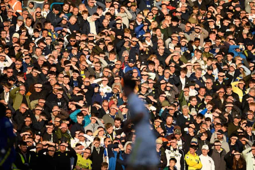 Leeds fans shield their eyes against the setting sun.