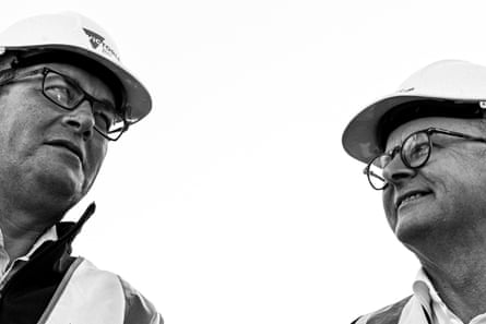 Black and white photo of Dan Andrews and Anthony Albanese in hard-hat gear, viewed from below.