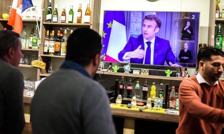 People watch Macron’s TV interview from a bar in Toulouse.