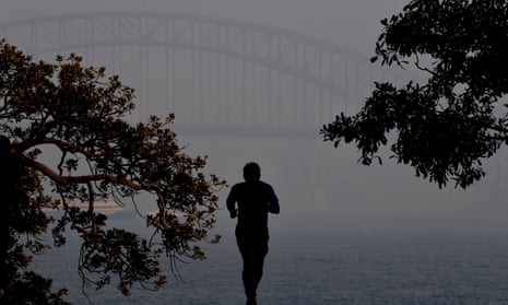 Person jogging in thick smoke obscuring the Sydney Harbour