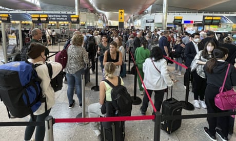 Travellers queueing to pass through security at Heathrow airport.