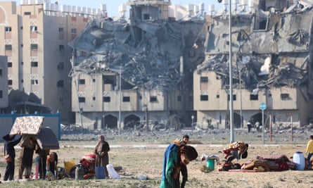 Palestinians carry their belongings after Israeli strikes on residential buildings in Khan Younis