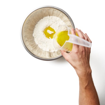 Making flatbread dough by pouring oil into flour.