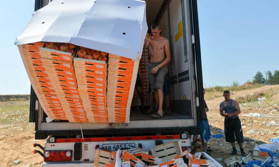 Workers throw peaches off a truck outside the city of Novozybkov