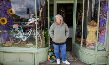Sue O’Rourke standing outside her shop smiling with hands in pockets