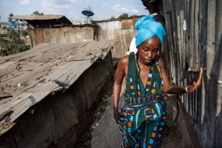 Social justice activist Wanjira Wanjiru walks along a precarious ledge between shanties at Mathare slum, Nairobi.