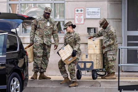 Troops load boxes of rifle ammunition into a car