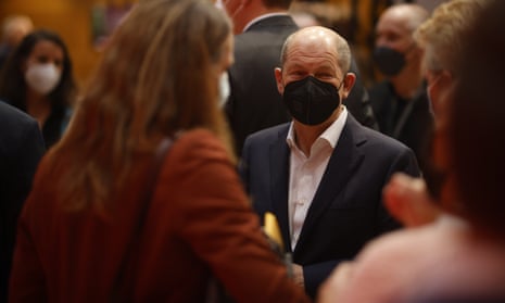 Germany’s new chancellor Olaf Scholz at the Social Democrats’ (SPD) party conference in Berlin, Germany on 4 December. He wears a black face mask and talks to delegates.