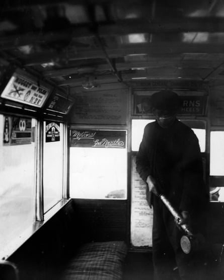 A man sprays the inside of a bus of the London omnibus with an anti-flu preparation in 1920.