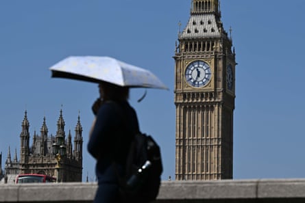 A person walks past Big Ben with an umbrella.