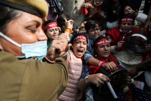 A police officer tries to detain the supporters of the women’s wing of India’s main opposition Congress Party during a protest against what they say is rising inflation in the country.