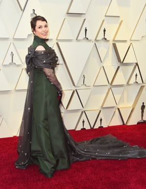 Arriving on the red carpet with Lady Gaga in a bustier, Olivia Colman made her own quiet impact. Her forest green Prada dress came with an interesting take on the cape trend - hers was worn on the front, and came in a flower decorated tulle