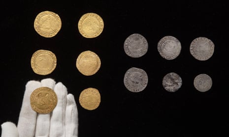 Coins on display with one in gloved hand