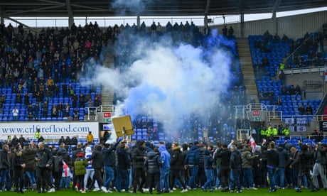 Reading match abandoned after fans storm pitch in protest against owner – video