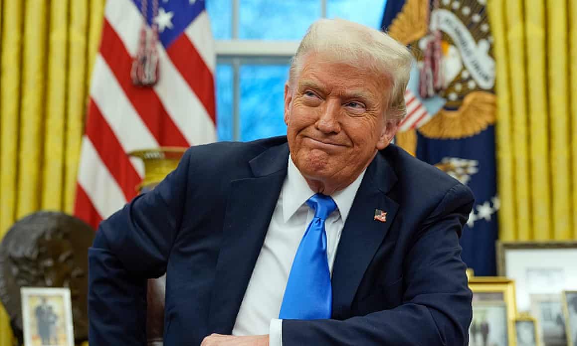 Trump in blue tie with flags, curtains, window behind