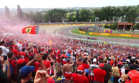 Ferrari supporters wave flags and set off flares.