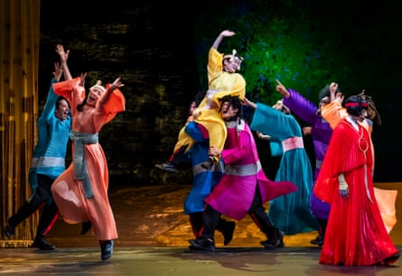 a group of people making theatrical gestures in brightly coloured robes