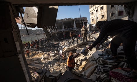 Palestinos buscan supervivientes y cadáveres entre los escombros de un edificio residencial destruido en un ataque aéreo israelí en Rafah, en el sur de Gaza.