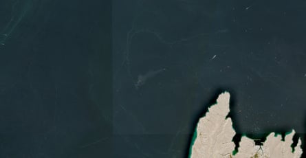 A satellite image shows containers and items floating in the water