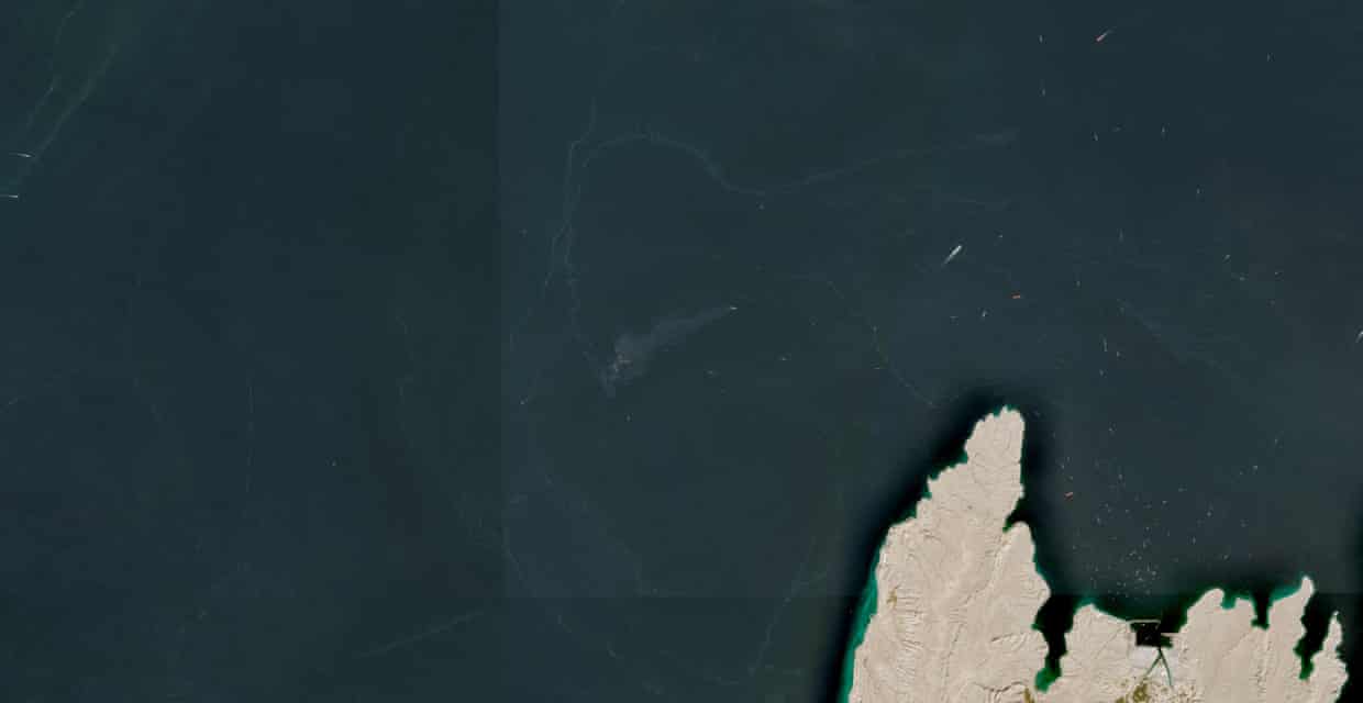 A satellite image shows containers and items floating in the water
