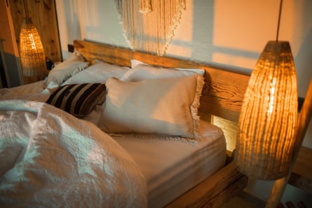 Hanging handmade wicker lamps in a bedroom showing a warm glow across the bed