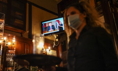A television in a London pub shows Boris Johnson making his address to the nation on Tuesday