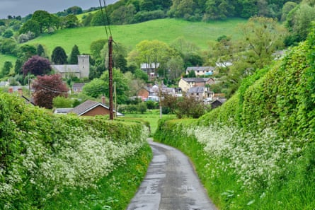 A country lane with a view downhill to a small town with church