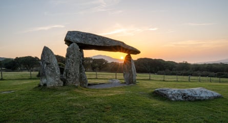 Pentre Ifan’s stone dolmen with a large capstone stands in a Welsh field at sunset