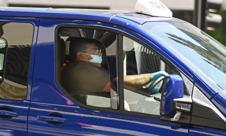 A taxi driver wearing a protective face mask driving in Bristol