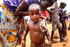 A mother washes her baby at Sebu refugee camp in Bamako, Mali