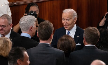 man in a suit talking to a bunch of people