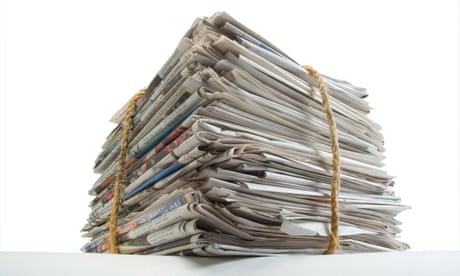 Stack of old newspapers bound with string ready for recycling.