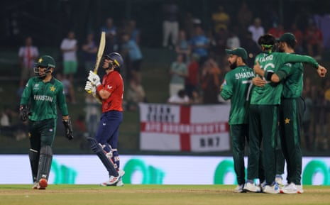 England's Sam Curran holds his bat against his helmet as he walks off the pitch after losing his wicket.